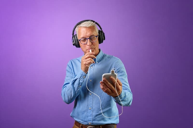 Close-up of a person using a tinnitus therapy device while listening to sound.